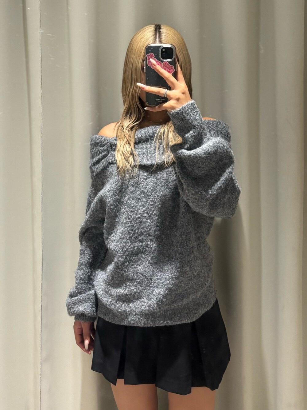 グレー系のニット/セーター、ブラック系のスカート、ブラック系のブーツを着用したレディースの秋コーディネートの4枚目の写真