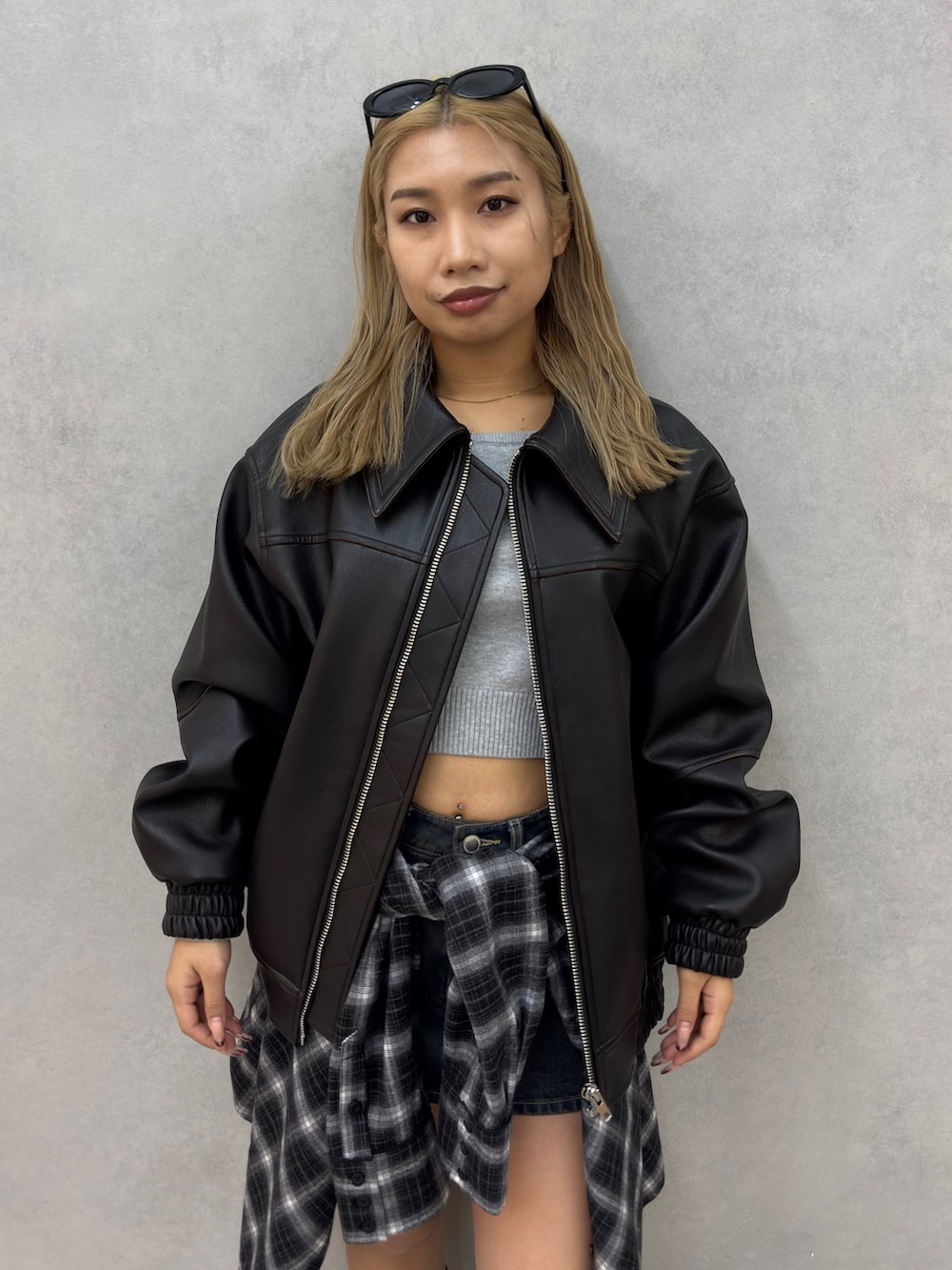 グレー系のニット/セーター、ブラック系のブルゾン、ブラック系のシャツ/ブラウスを着用したレディースの冬コーディネートの4枚目の写真