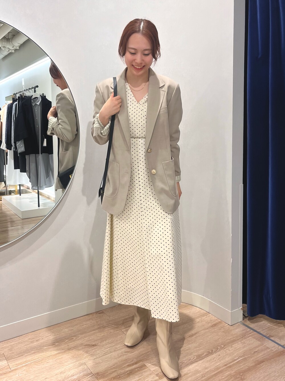 ベージュ系のテーラードジャケット、ホワイト系のワンピースを着用したレディースの秋コーディネートの3枚目の写真