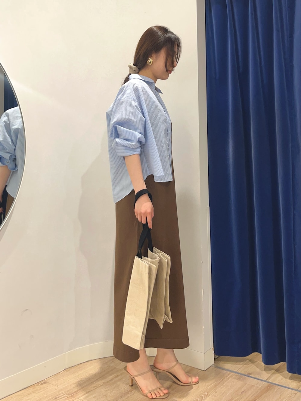 ブルー系のシャツ/ブラウス、ブラウン系のワンピース、ブラック系のバックパック/リュックを着用したレディースの夏コーディネートの2枚目の写真