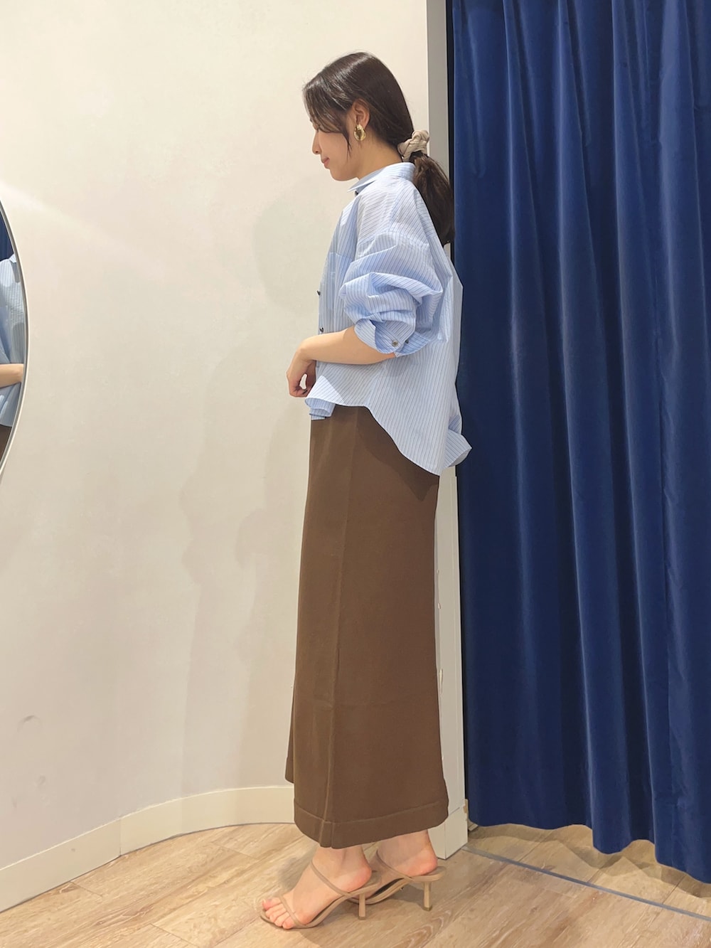 ブルー系のシャツ/ブラウス、ブラウン系のワンピース、ブラック系のバックパック/リュックを着用したレディースの夏コーディネートの4枚目の写真