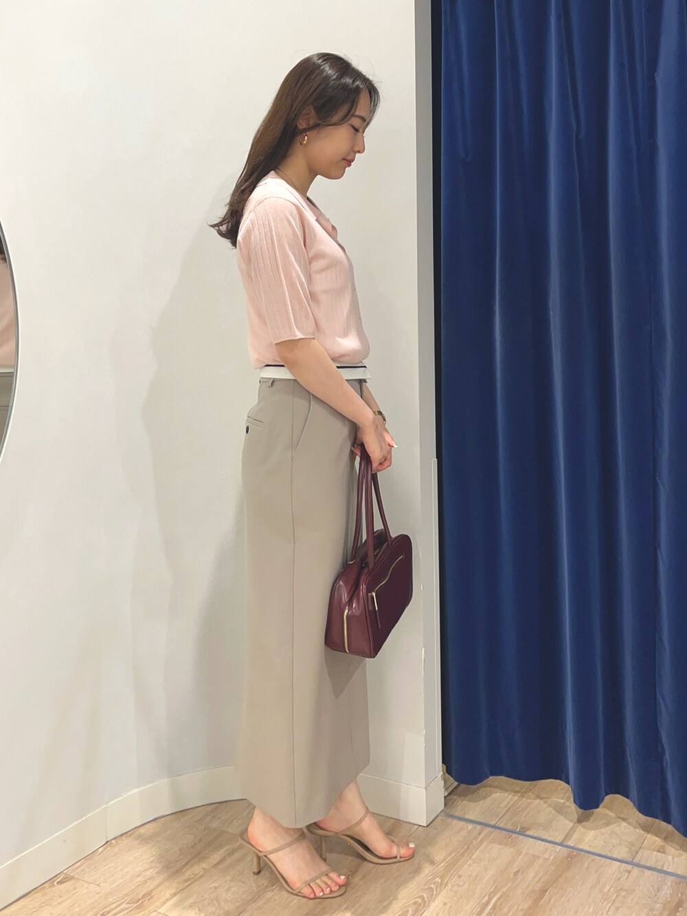 グリーン系のスカート、ピンク系のカーディガン/ボレロ、レッド系のボストンバッグを着用したレディースの夏コーディネートの2枚目の写真