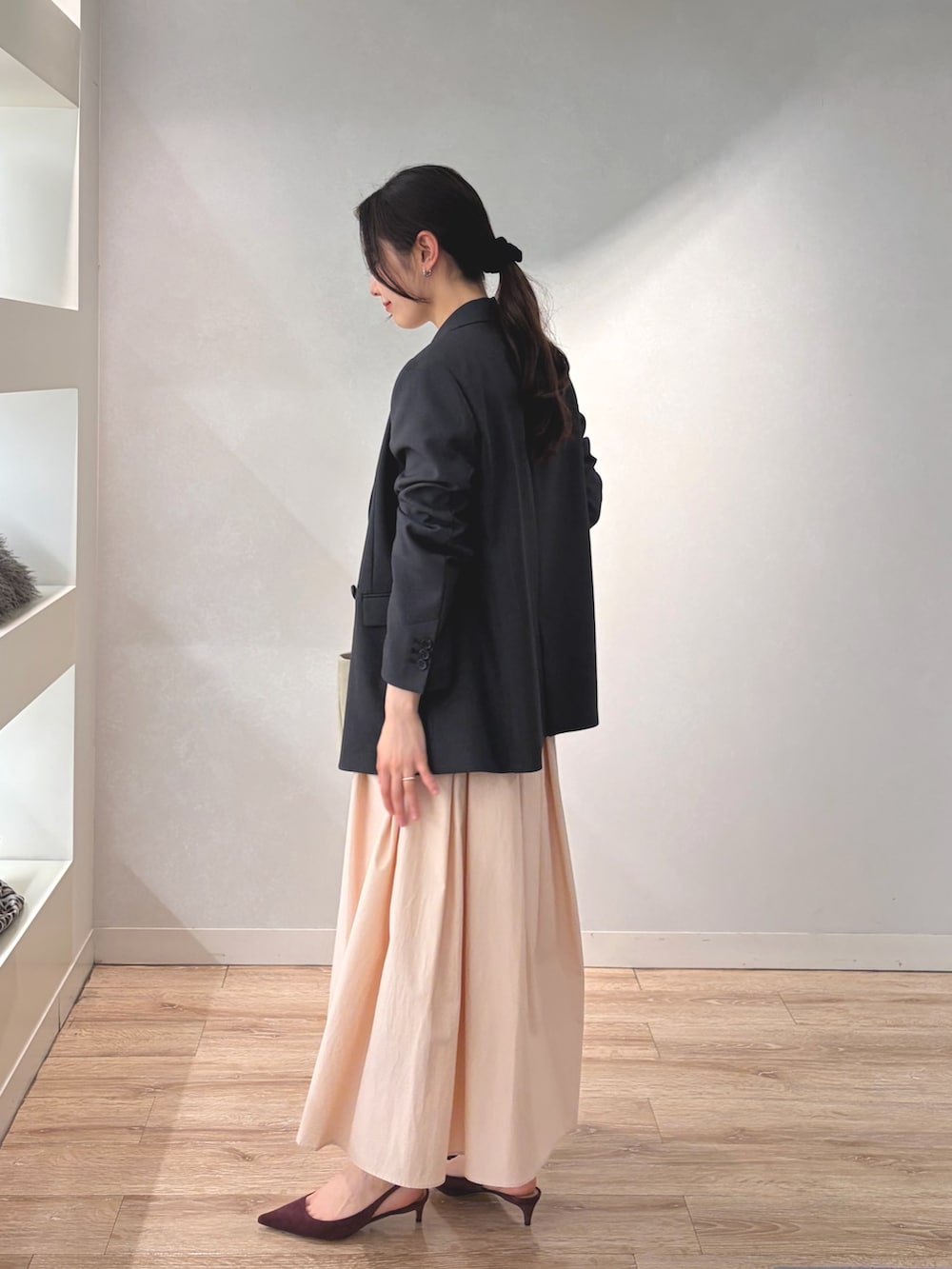 グレー系のテーラードジャケット、ホワイト系のニット/セーター、ベージュ系のトートバッグを着用したレディースの冬コーディネートの4枚目の写真