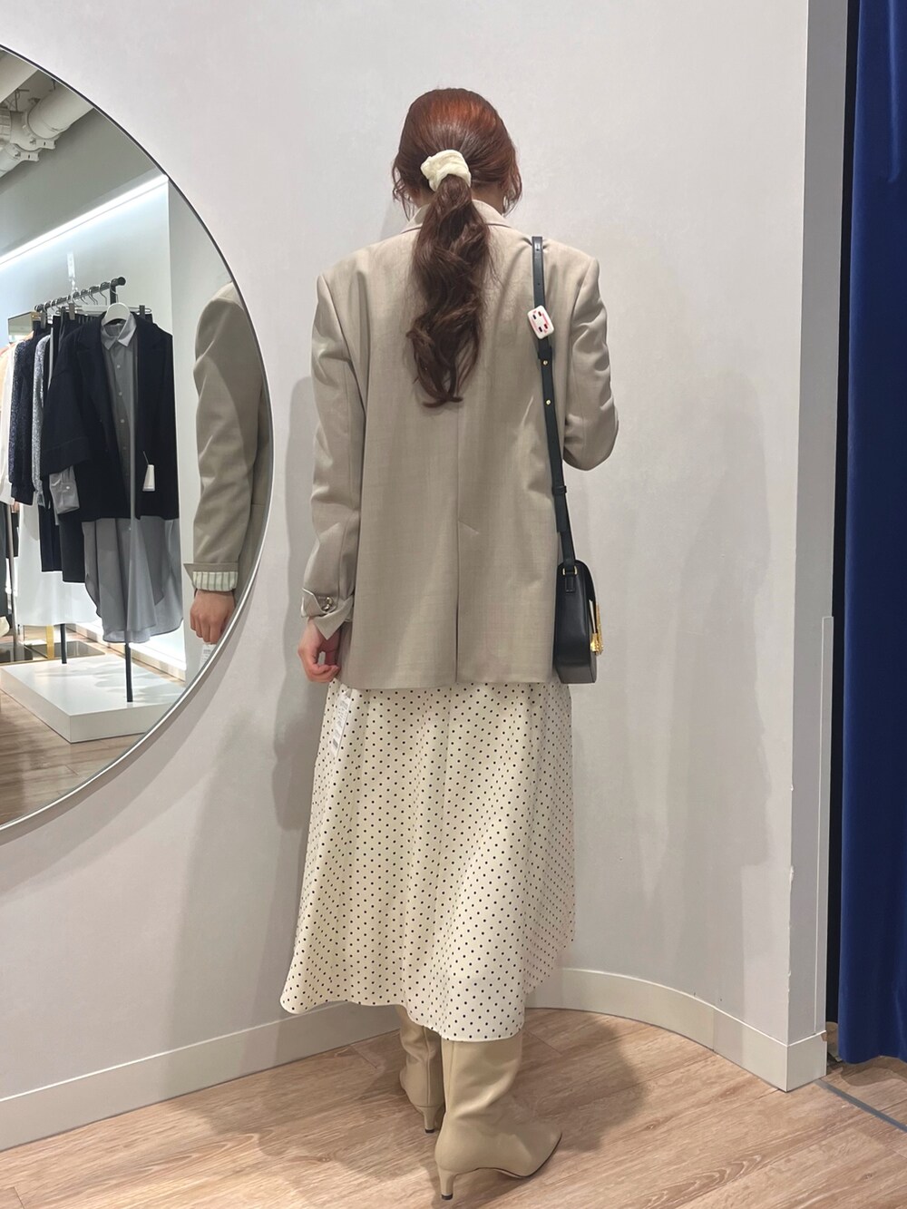 ベージュ系のテーラードジャケット、ホワイト系のワンピースを着用したレディースの秋コーディネートの5枚目の写真