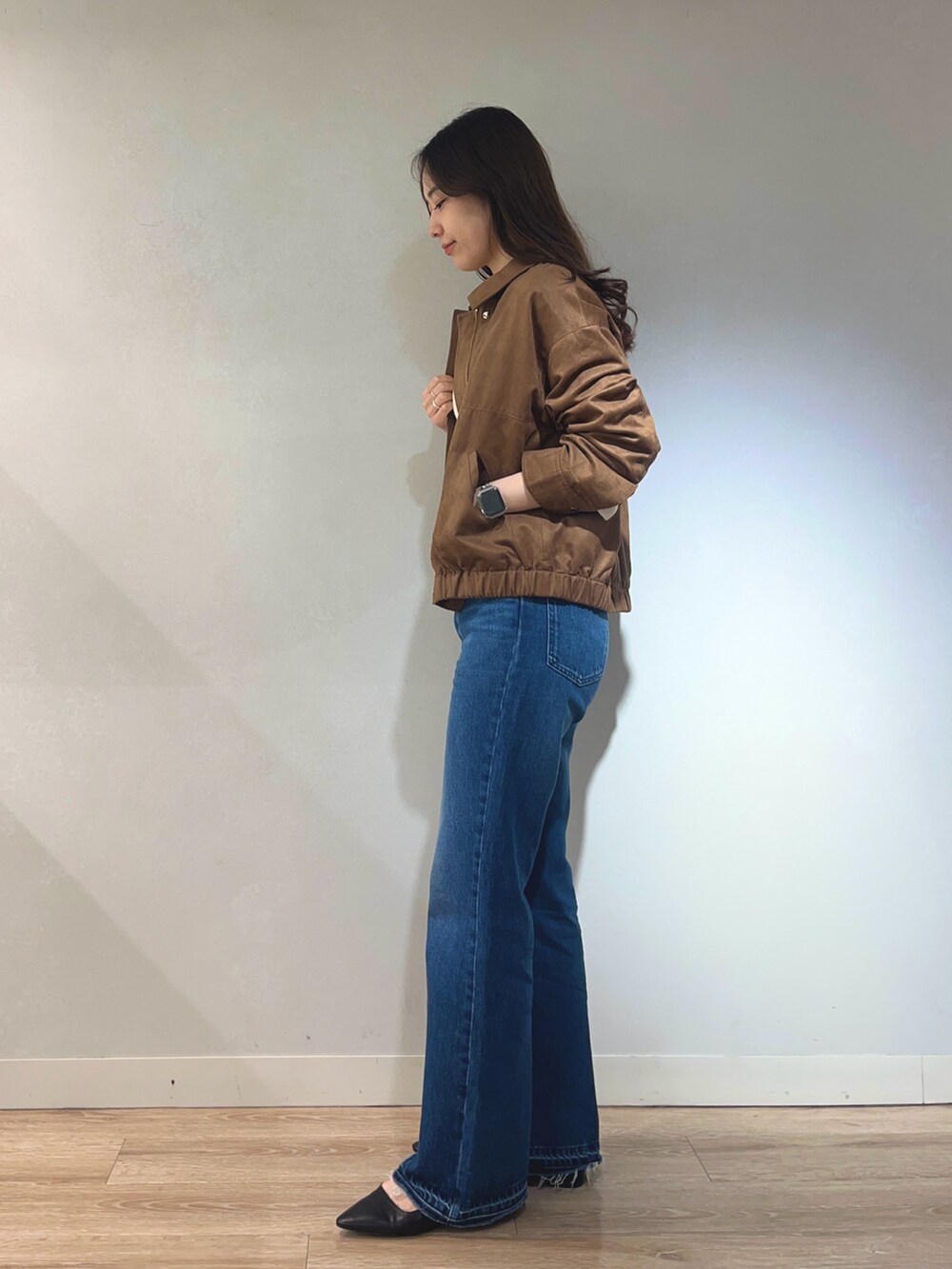 ブルー系のデニムパンツ、ホワイト系のニット/セーター、イエロー系のブルゾンを着用したレディースの秋コーディネートの3枚目の写真