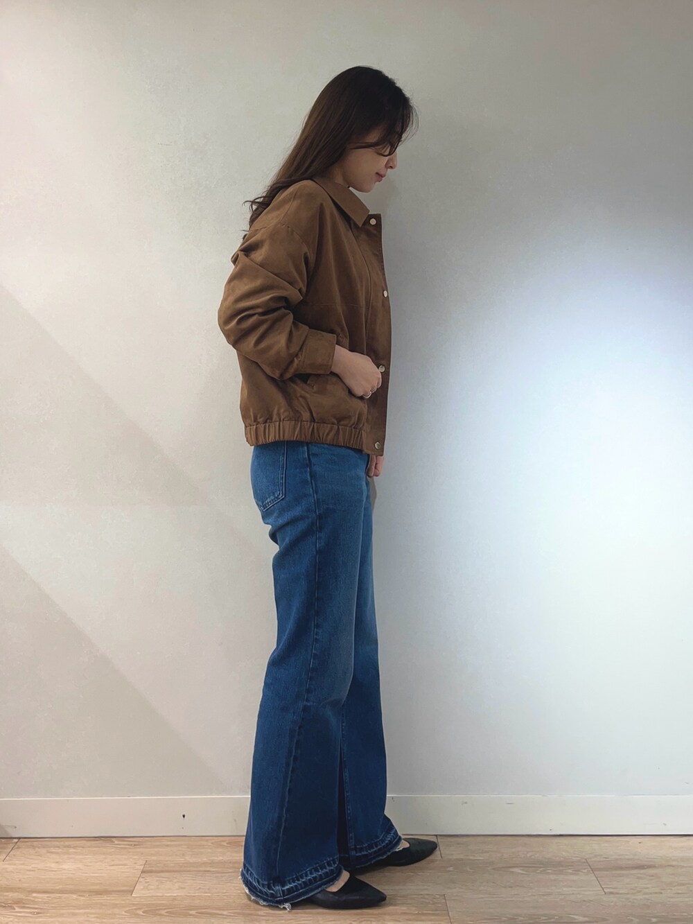 ブルー系のデニムパンツ、ホワイト系のニット/セーター、イエロー系のブルゾンを着用したレディースの秋コーディネートの5枚目の写真