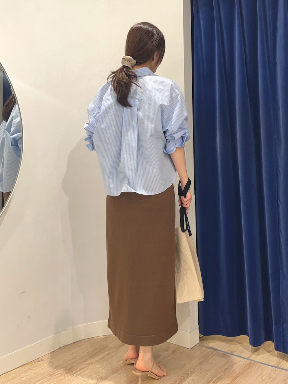 ブルー系のシャツ/ブラウス、ブラウン系のワンピース、ブラック系のバックパック/リュックを着用したレディースの夏コーディネートの3枚目の写真