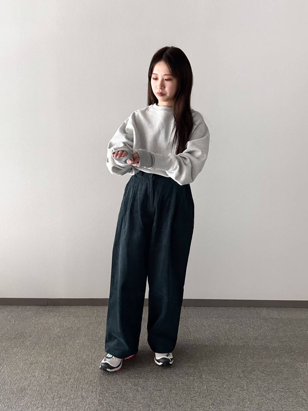 シルバー系のスウェット、ホワイト系のスニーカー、ブルー系のその他パンツを着用したレディースの冬コーディネートの3枚目の写真