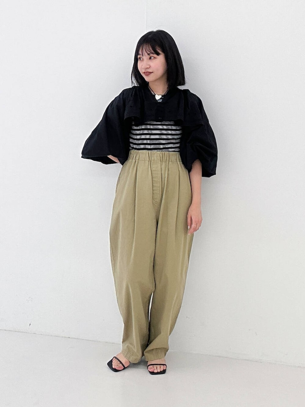 ベージュ系のその他パンツ、ブラック系のサンダル、ブラック系のTシャツ/カットソーを着用したレディースの夏コーディネートの3枚目の写真