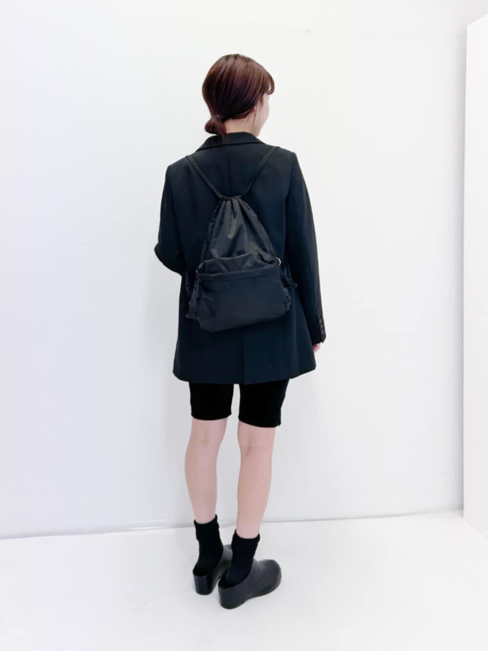 ブラック系のその他アウター、ブラック系のバックパック/リュック、ブラック系のその他パンツを着用したレディースの冬コーディネートの3枚目の写真