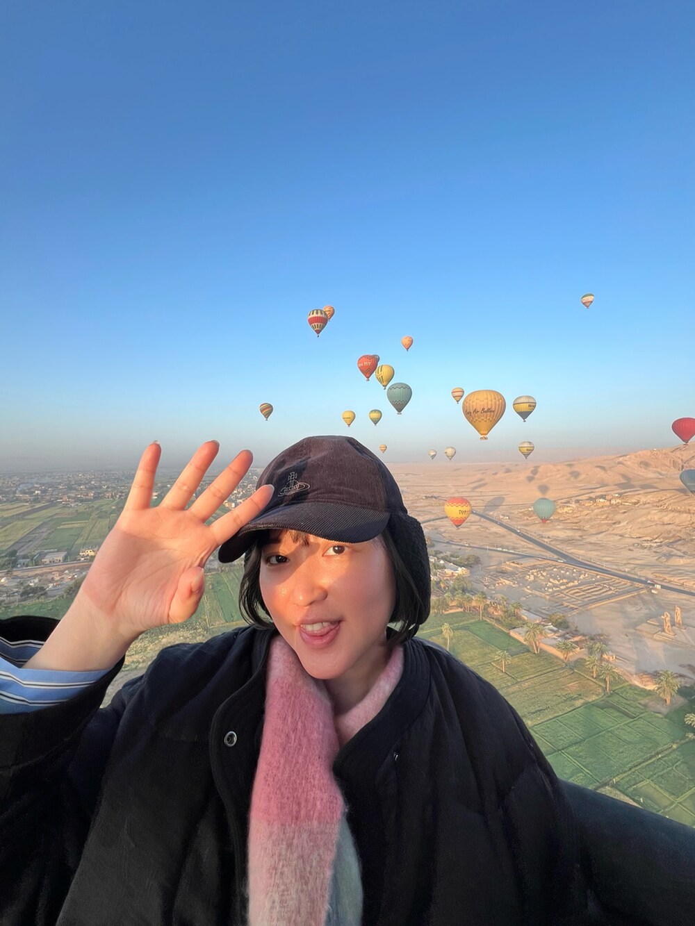 ブラック系のダウンジャケット/コート、ブラック系のデニムパンツ、ホワイト系のスニーカーを着用したレディースの夏コーディネートの2枚目の写真