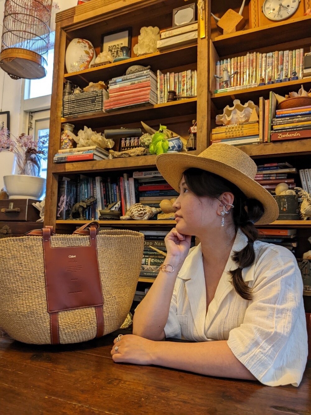 ブラウン系のかごバッグ、ホワイト系のつなぎ/オールインワン、シルバー系のリングを着用したレディースの春コーディネートの2枚目の写真
