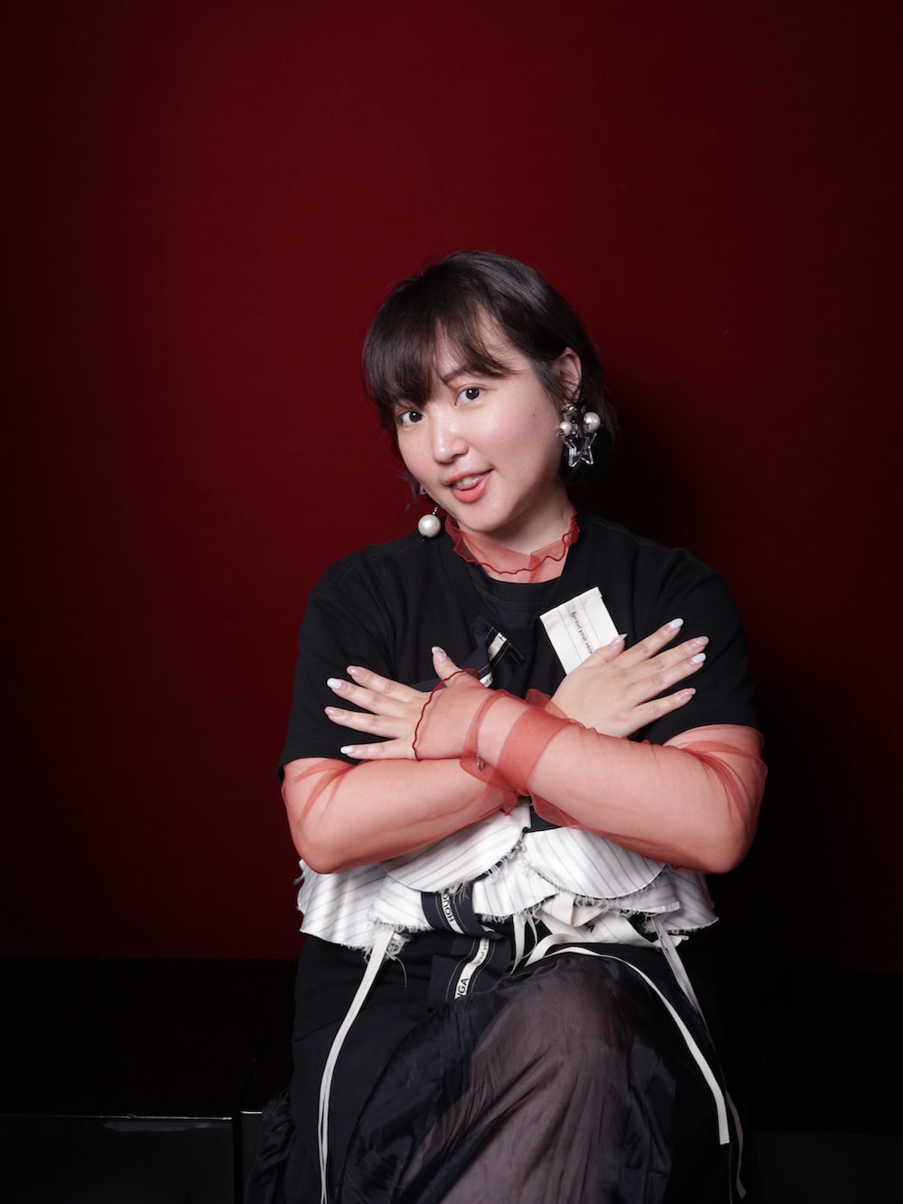 シルバー系のスニーカー、ブラック系のTシャツ/カットソー、レッド系のその他トップスを着用したレディースの冬コーディネートの3枚目の写真