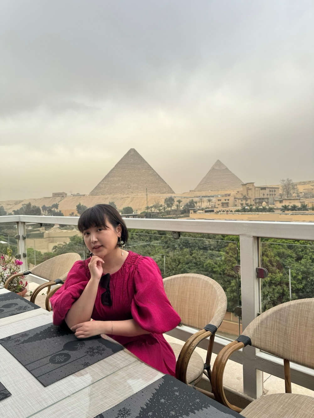 レッド系のワンピース、ブラック系のショルダーバッグ、ブラック系のサンダルを着用したレディースの夏コーディネートの4枚目の写真