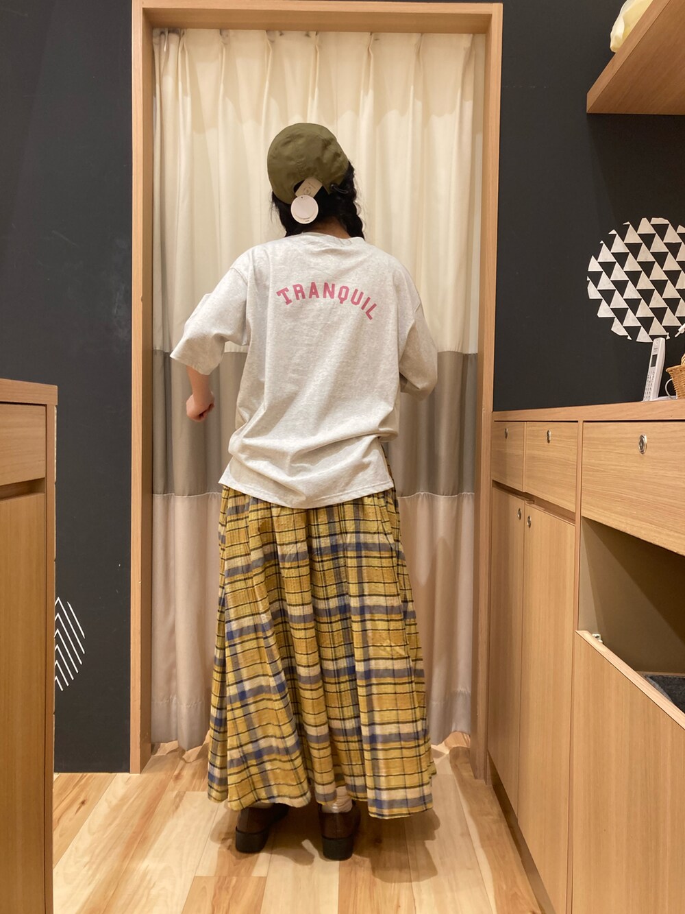 イエロー系のスカート、ホワイト系のTシャツ/カットソー、グリーン系のキャップを着用したレディースの春コーディネートの2枚目の写真