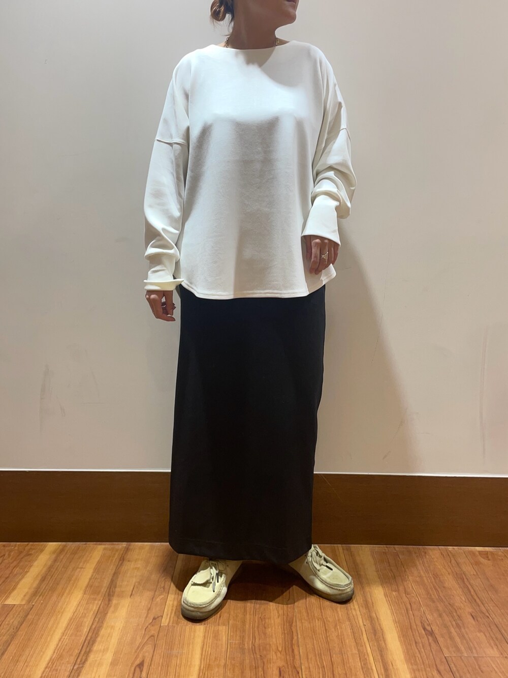 ホワイト系のTシャツ/カットソー、ブラック系のスカート、イエロー系のストール/ショールを着用したレディースの秋コーディネートの2枚目の写真