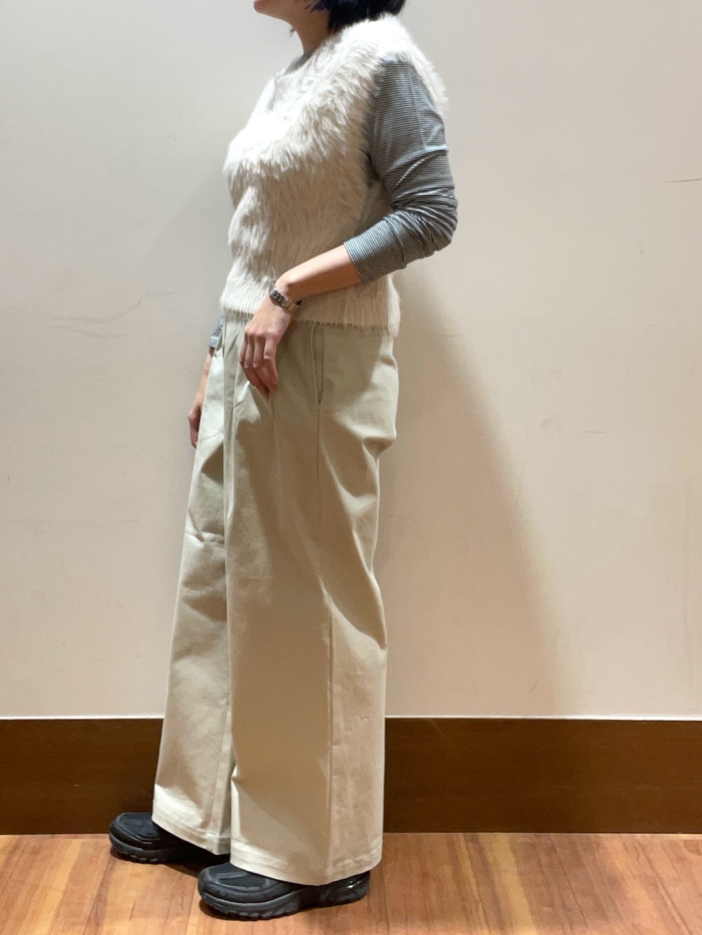 グレー系のベスト、ベージュ系のその他パンツ、ブラック系のTシャツ/カットソーを着用したレディースの冬コーディネートの2枚目の写真