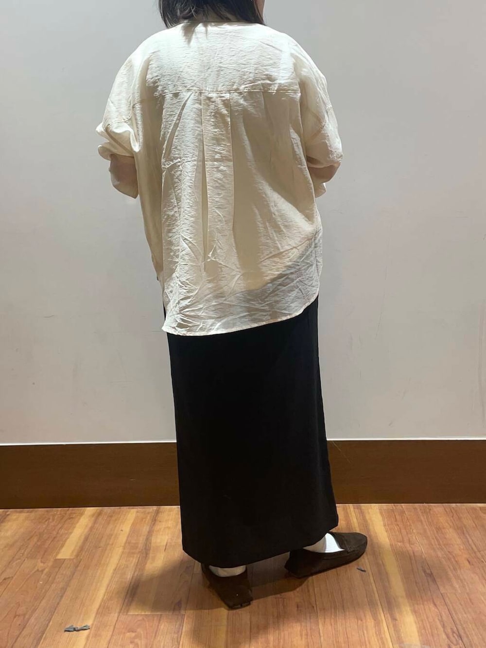 ホワイト系のシャツ/ブラウス、ブラック系のスカート、ホワイト系のTシャツ/カットソーを着用したレディースの春コーディネートの2枚目の写真