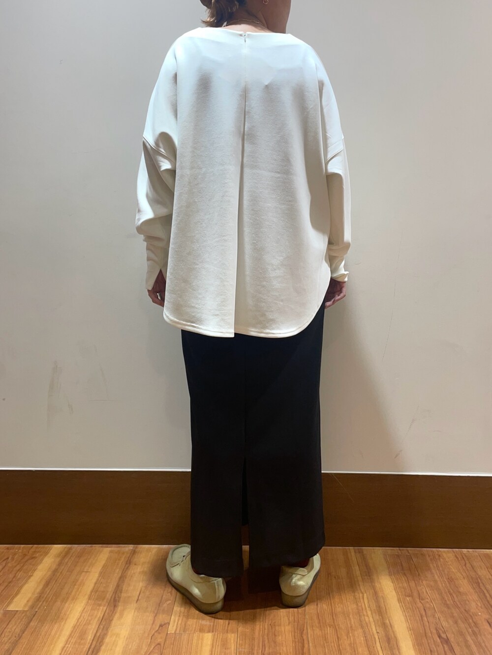 ホワイト系のTシャツ/カットソー、ブラック系のスカート、イエロー系のストール/ショールを着用したレディースの秋コーディネートの4枚目の写真