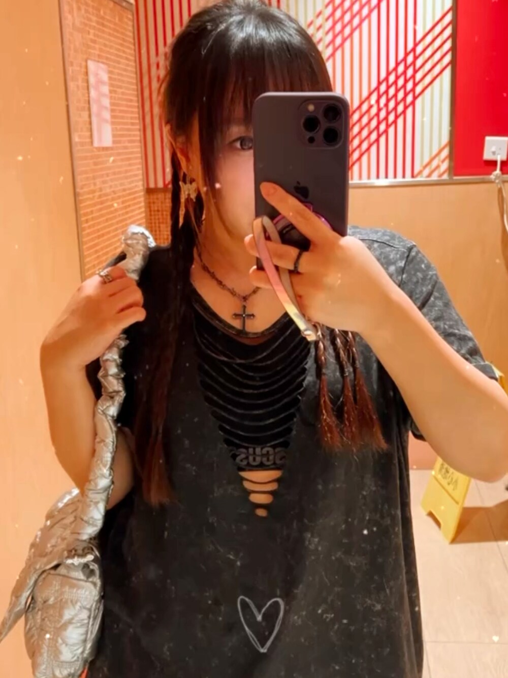 シルバー系のバッグ、ブラック系のトップスを着用したレディースの夏コーディネートの2枚目の写真