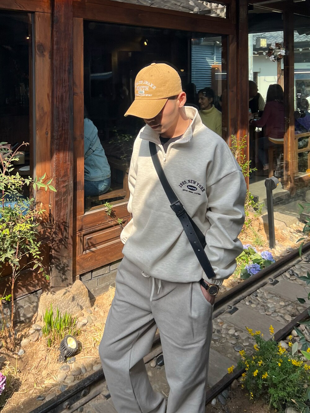 ブラック系のショルダーバッグ、ホワイト系のスニーカーを着用したメンズの春コーディネートの2枚目の写真