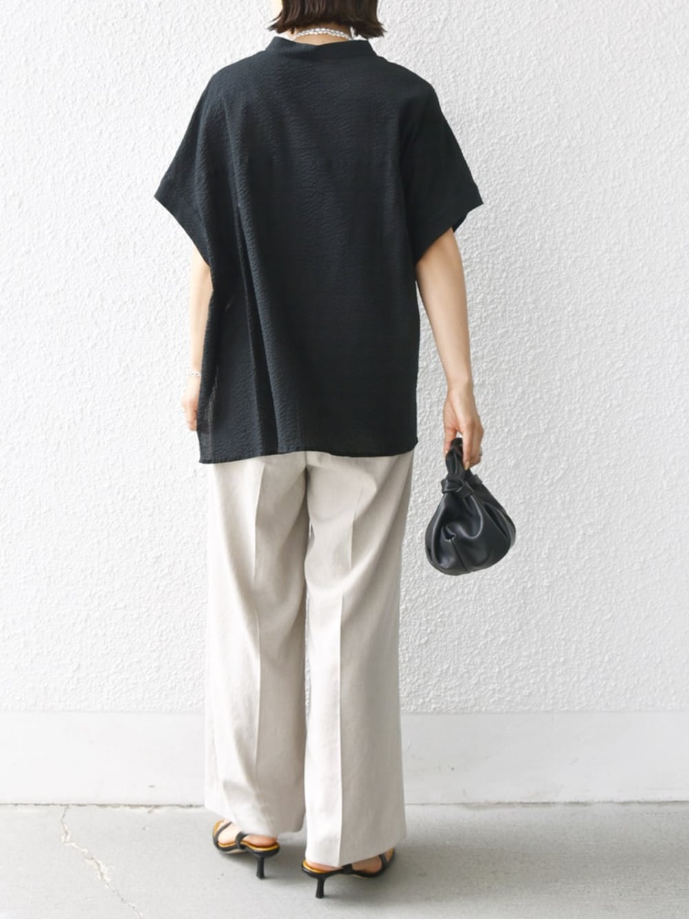 ベージュ系のその他パンツ、ブラック系のシャツ/ブラウス、ホワイト系のネックレスを着用したレディースの夏コーディネートの3枚目の写真