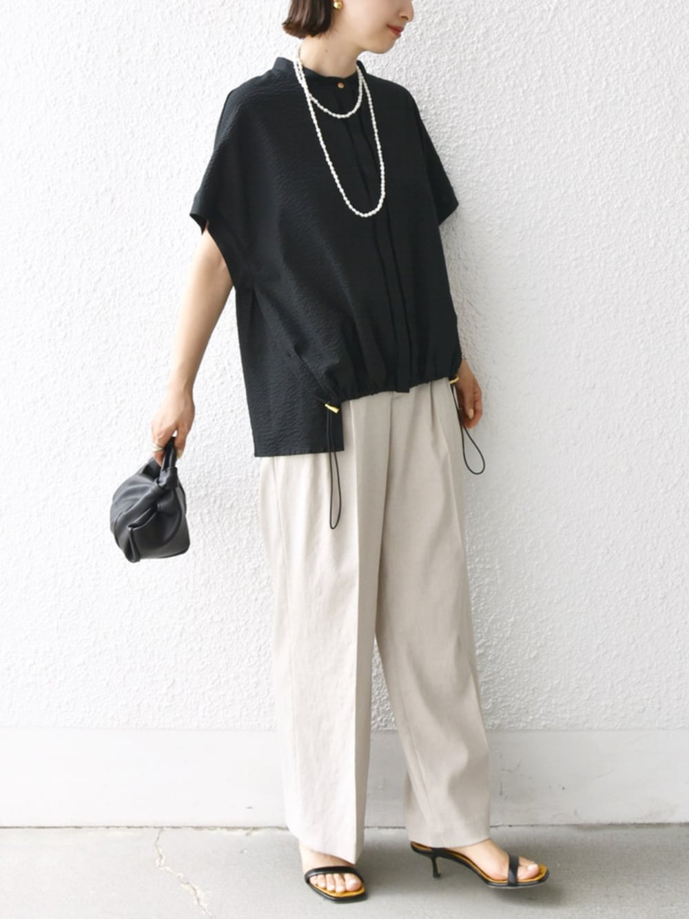 ベージュ系のその他パンツ、ブラック系のシャツ/ブラウス、ホワイト系のネックレスを着用したレディースの夏コーディネートの4枚目の写真