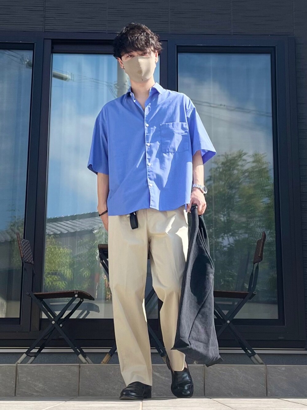 ブルー系のシャツ/ブラウス、ベージュ系のスラックス、ブラック系のローファーを着用したメンズの夏コーディネートの3枚目の写真