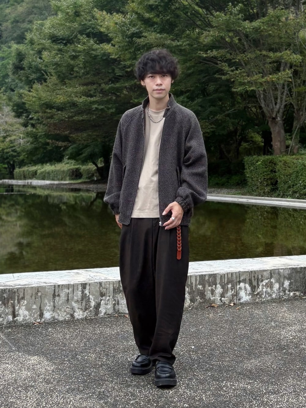 ベージュ系のTシャツ/カットソー、ブラウン系のブルゾン、ブラウン系のスラックスを着用したメンズの秋コーディネートの2枚目の写真