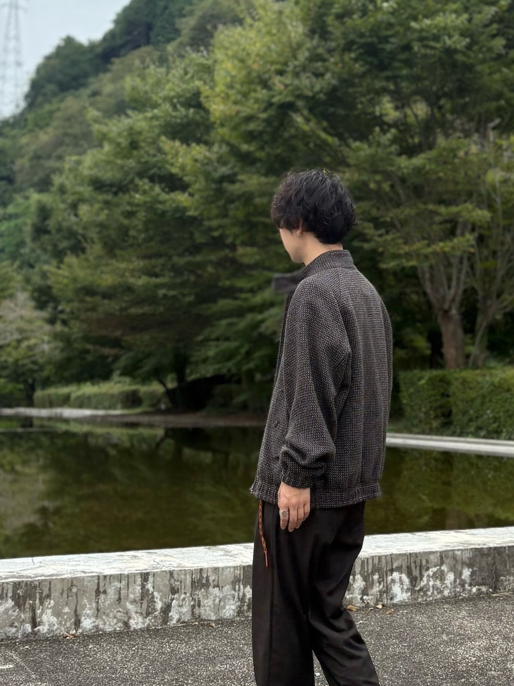 ベージュ系のTシャツ/カットソー、ブラウン系のブルゾン、ブラウン系のスラックスを着用したメンズの秋コーディネートの3枚目の写真