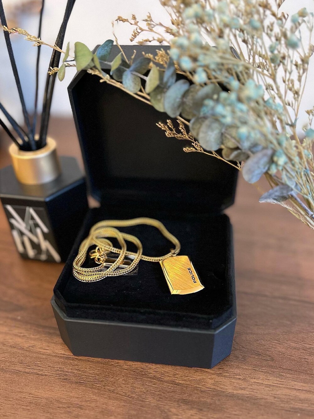 ブルー系のデニムパンツ、グレー系のトレンチコート、ブラック系のTシャツ/カットソーを着用したメンズの秋コーディネートの2枚目の写真