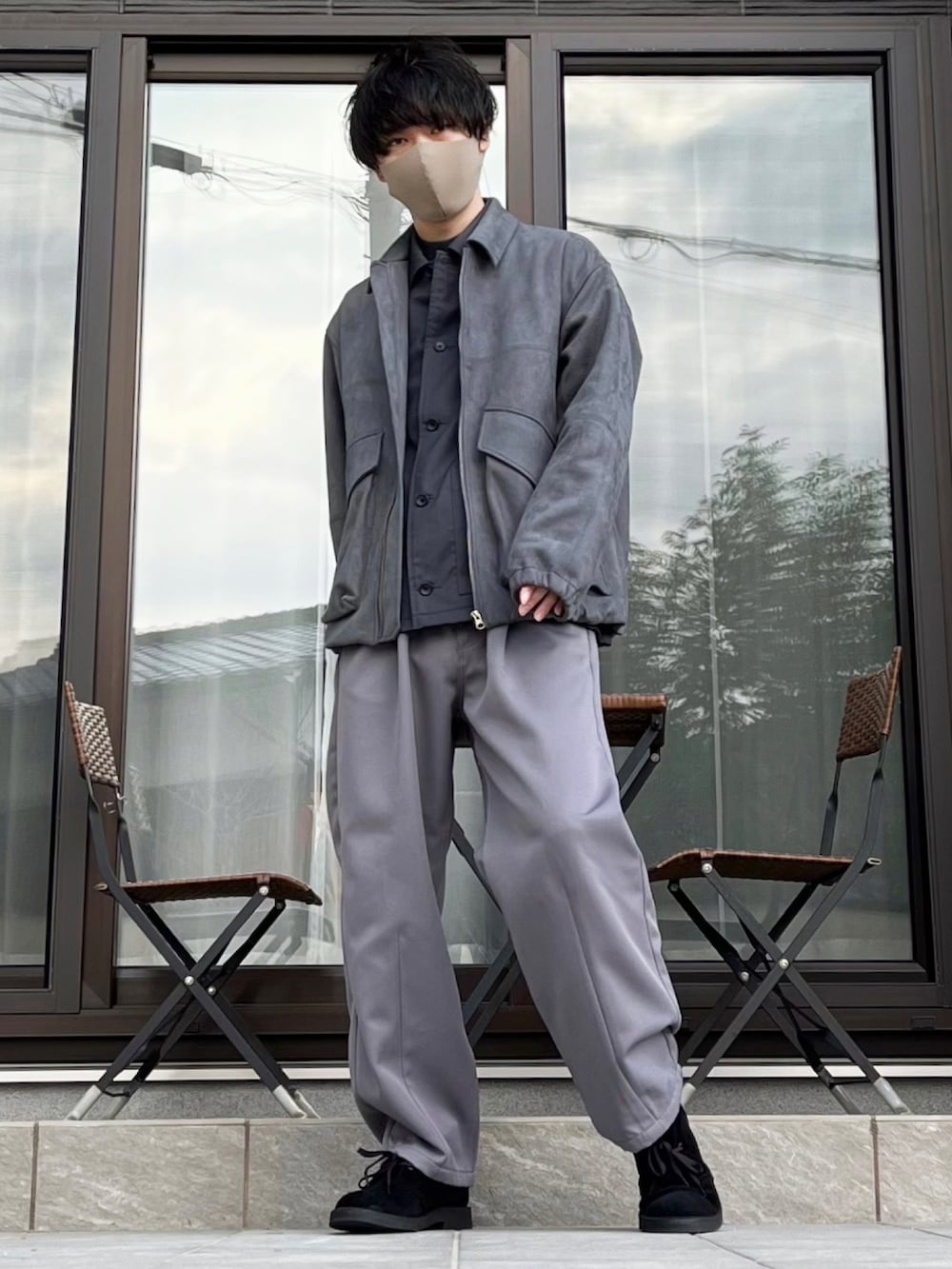 グレー系のスラックス、グレー系のブルゾン、ブラック系のブーツを着用したメンズの冬コーディネートの2枚目の写真