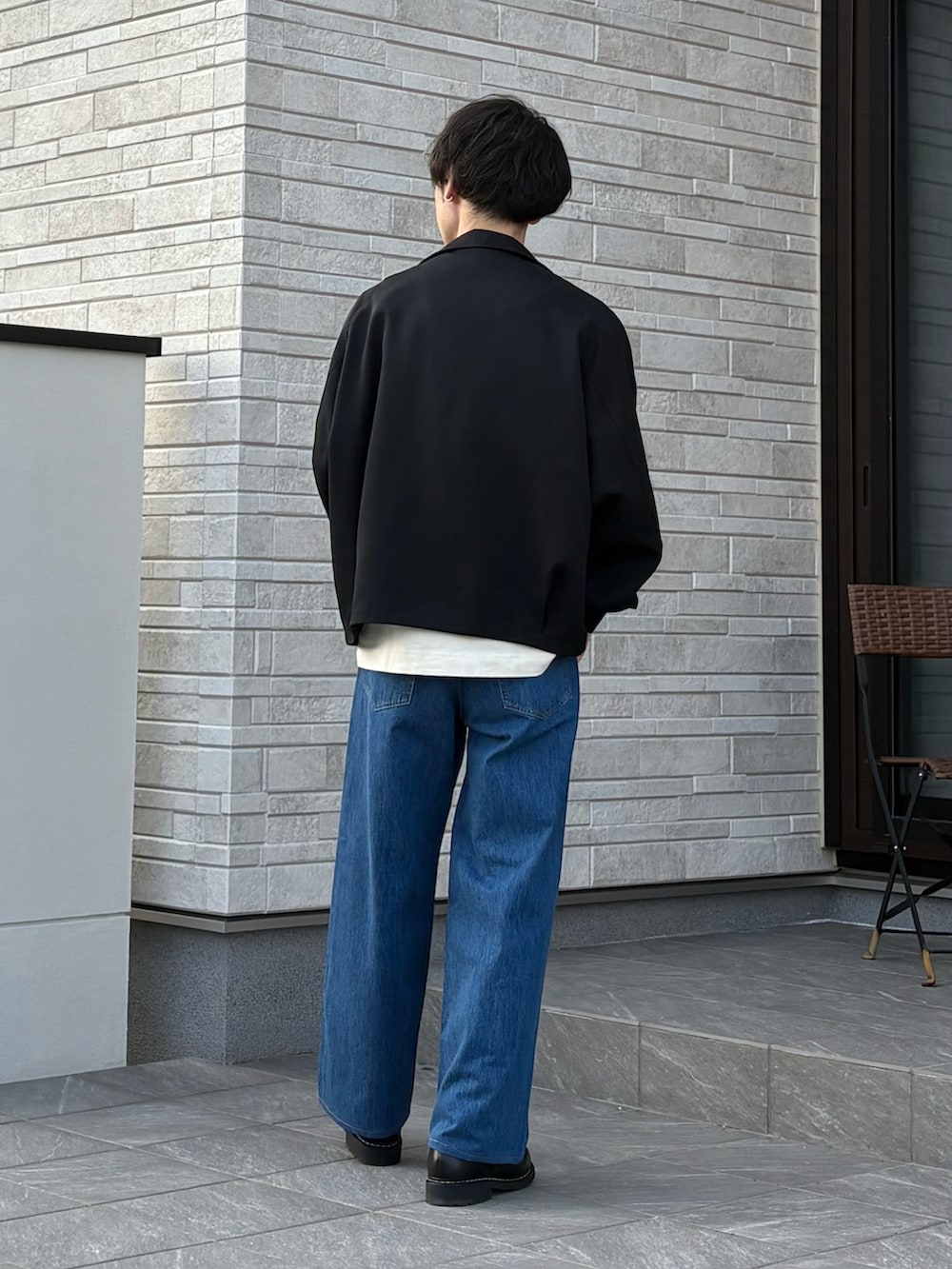 ホワイト系のTシャツ/カットソー、ブラック系のジャケット/アウター、ブルー系のデニムパンツを着用したメンズの春コーディネートの4枚目の写真