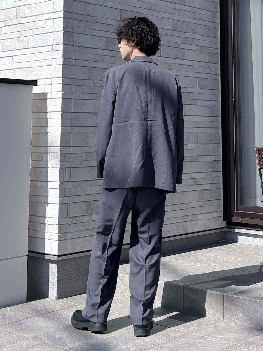 グレー系のセットアップを着用したメンズの春コーディネートの3枚目の写真