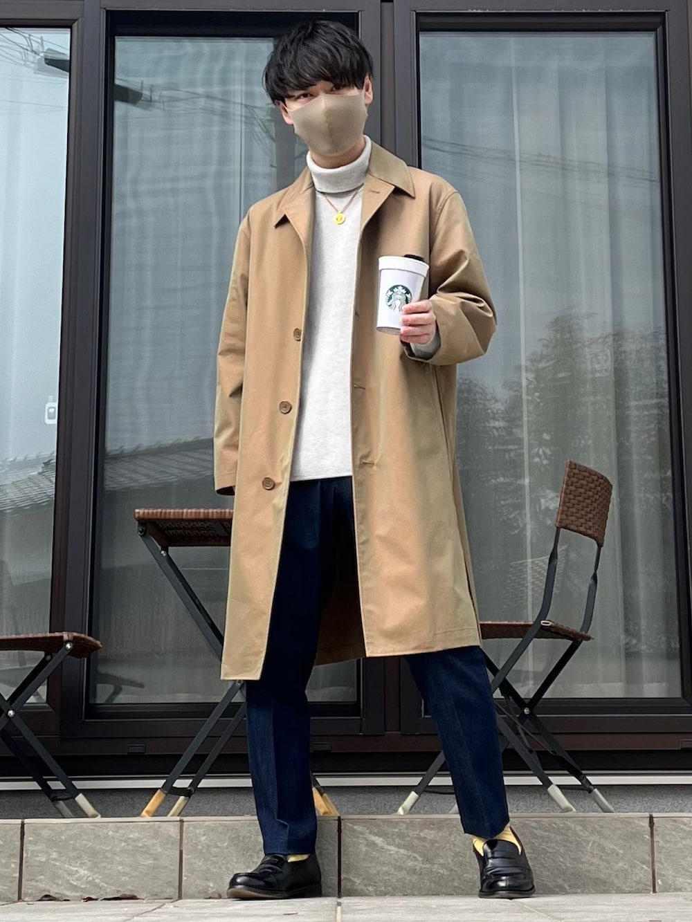 ベージュ系のステンカラーコート、グレー系のニット/セーター、ブルー系のデニムパンツを着用したメンズの春コーディネートの3枚目の写真