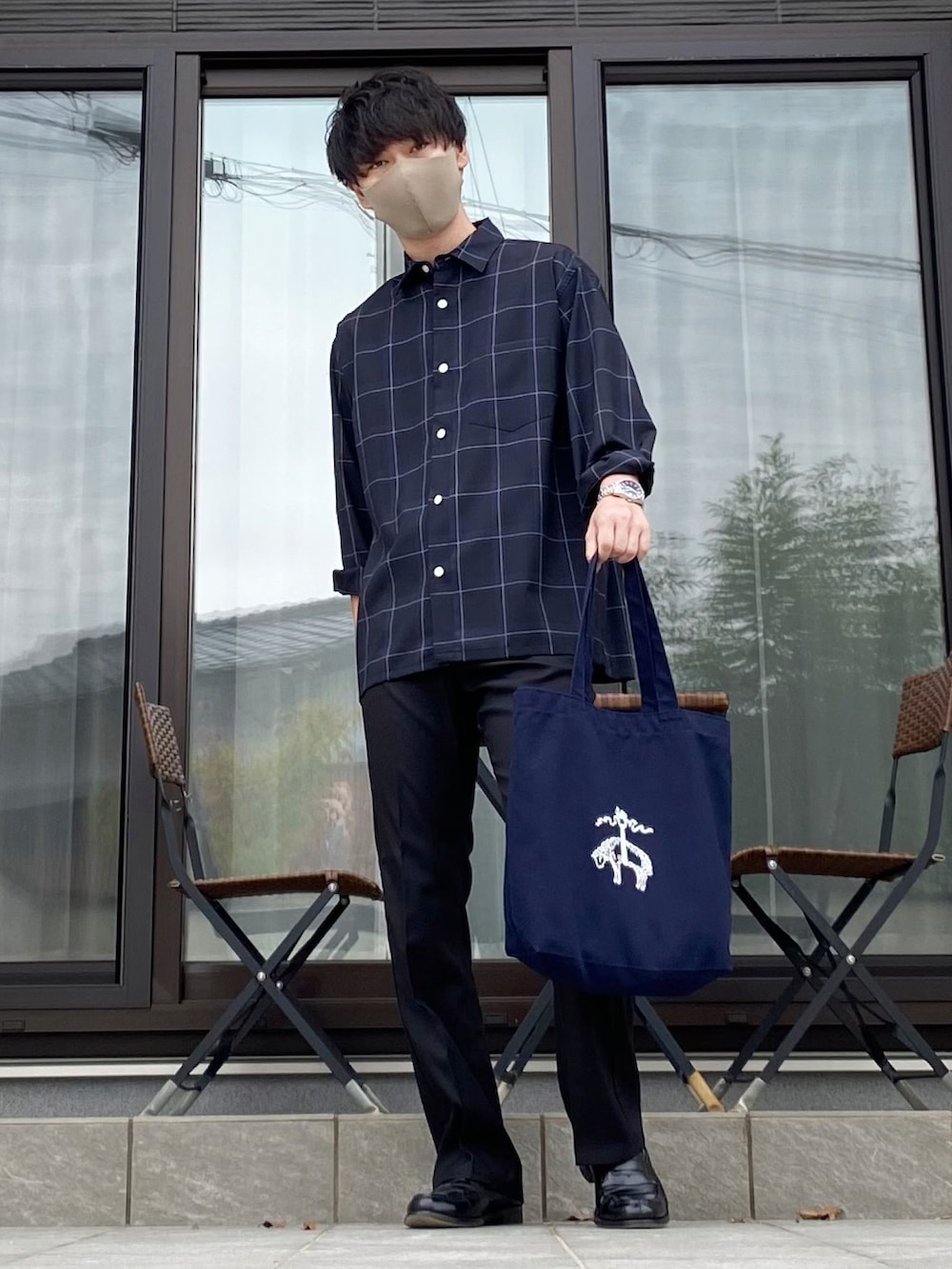 ブラック系のスラックス、ブルー系のシャツ/ブラウス、ブルー系のトートバッグを着用したメンズの秋コーディネートの3枚目の写真