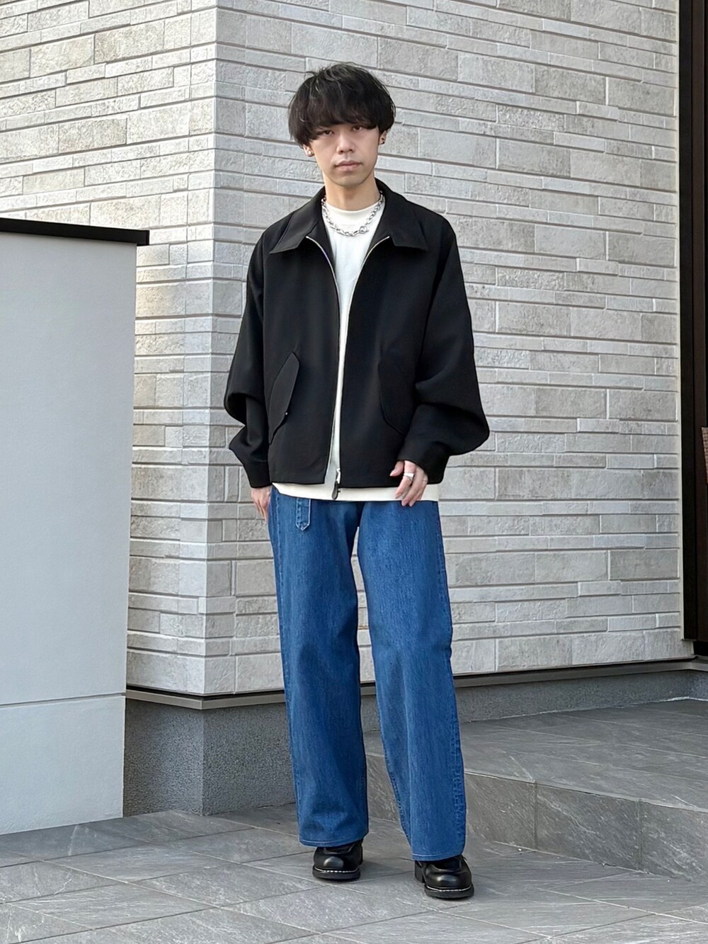 ホワイト系のTシャツ/カットソー、ブラック系のジャケット/アウター、ブルー系のデニムパンツを着用したメンズの春コーディネートの2枚目の写真
