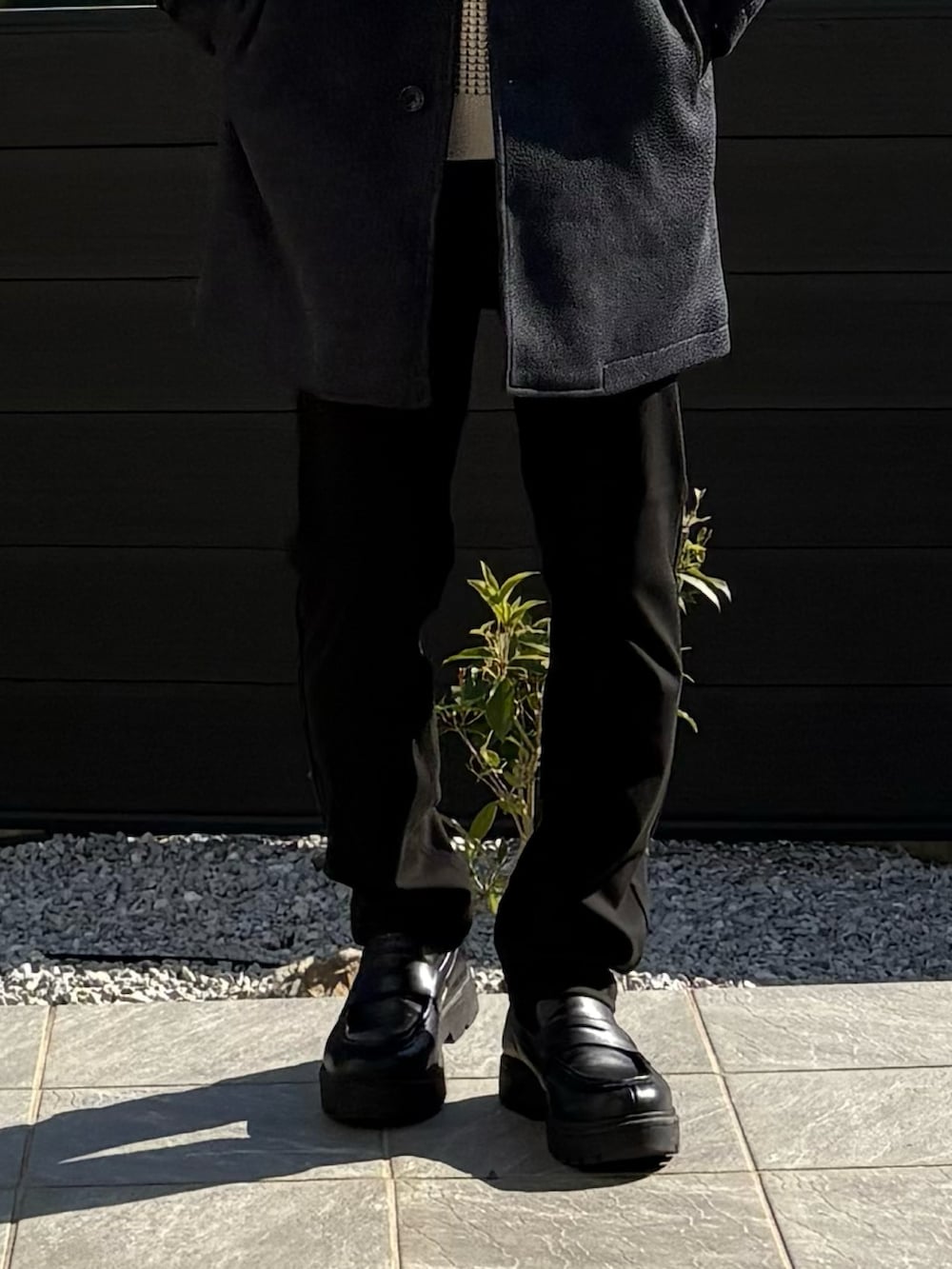 ブルー系のステンカラーコート、ベージュ系のスウェット、ブラック系のその他パンツを着用したメンズの秋コーディネートの4枚目の写真