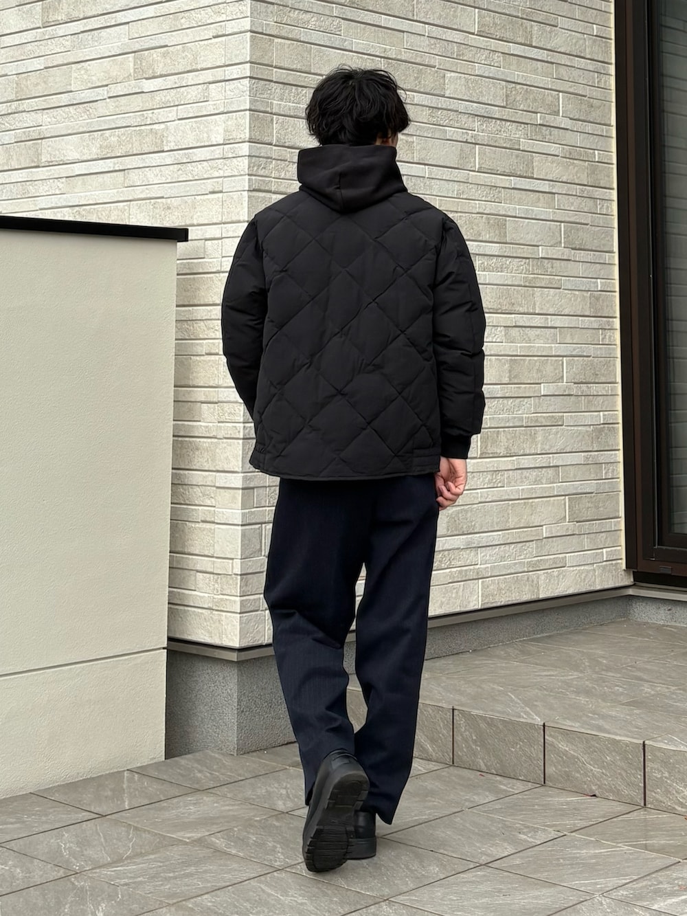 ブラック系のダウンジャケット/コート、ブラック系のローファーを着用したメンズの冬コーディネートの3枚目の写真
