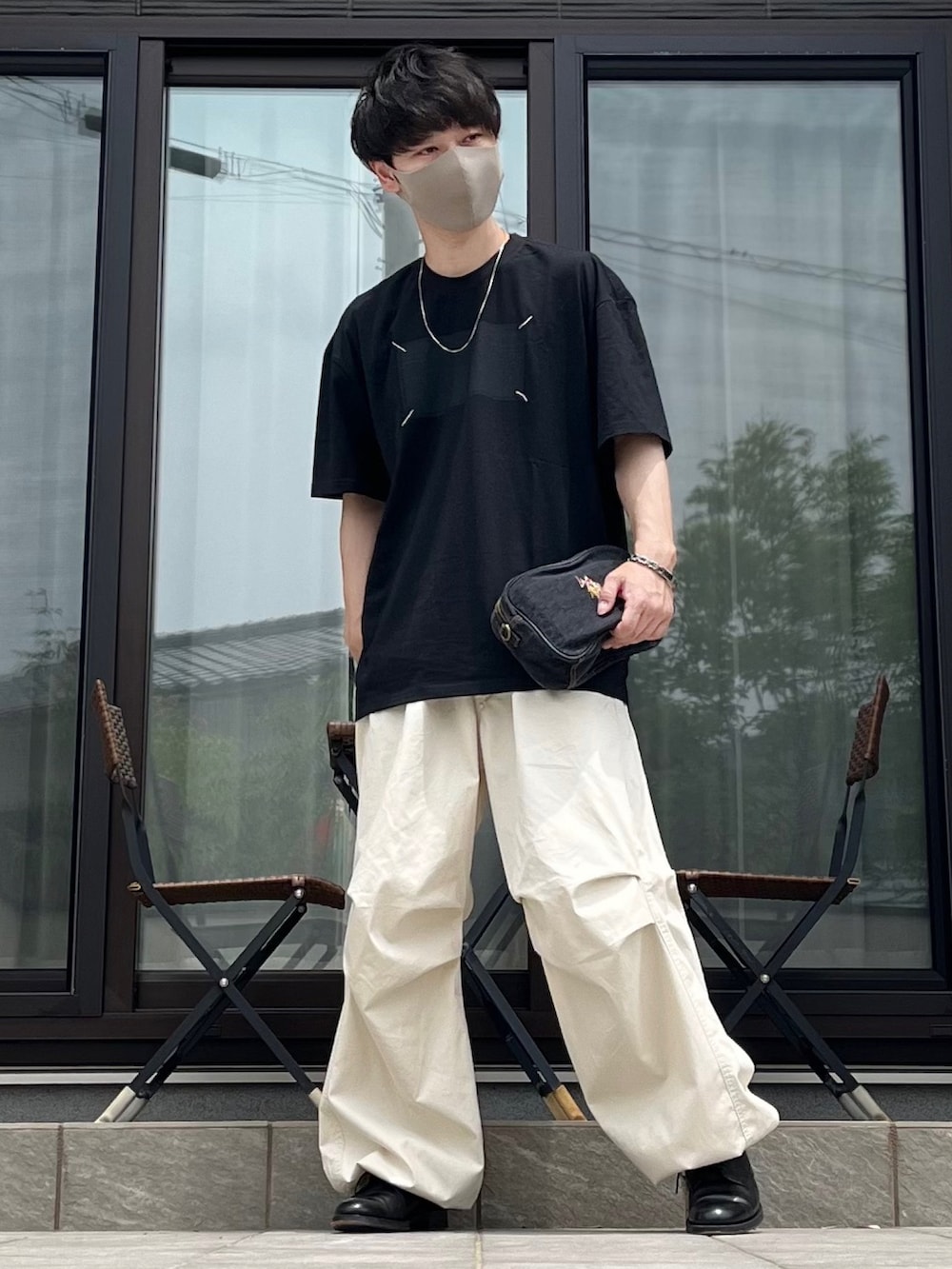 ホワイト系のカーゴパンツ、ブラック系のTシャツ/カットソー、ブラック系のドレスシューズを着用したメンズの夏コーディネートの2枚目の写真