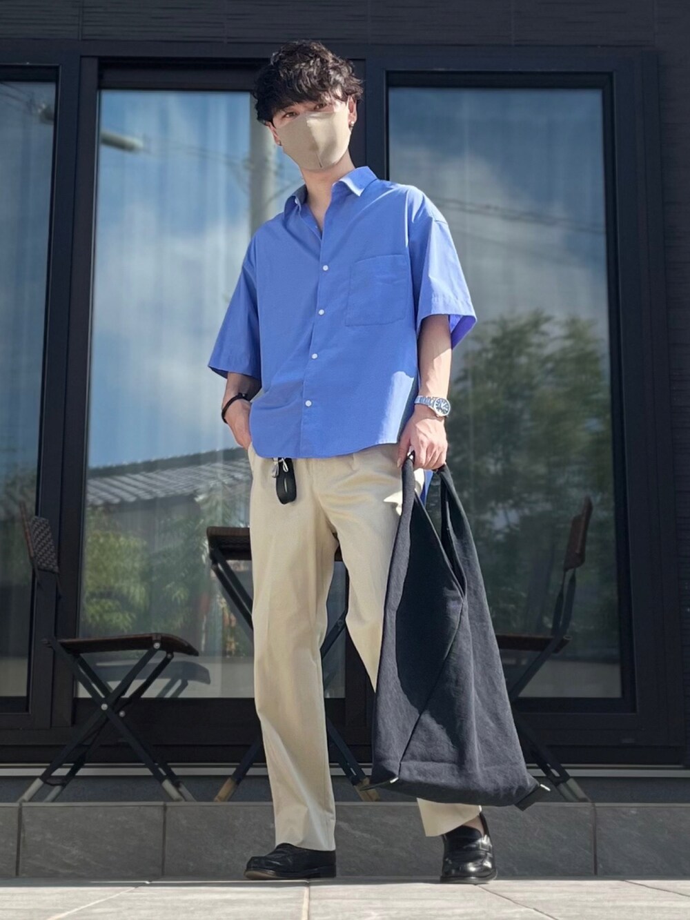 ブルー系のシャツ/ブラウス、ベージュ系のスラックス、ブラック系のローファーを着用したメンズの夏コーディネートの2枚目の写真