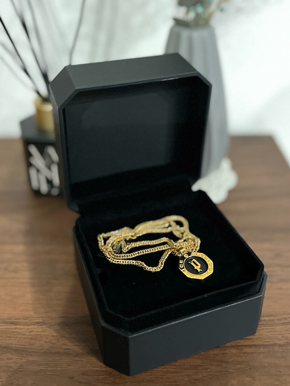 ベージュ系のステンカラーコート、グレー系のニット/セーター、ブルー系のデニムパンツを着用したメンズの春コーディネートの2枚目の写真