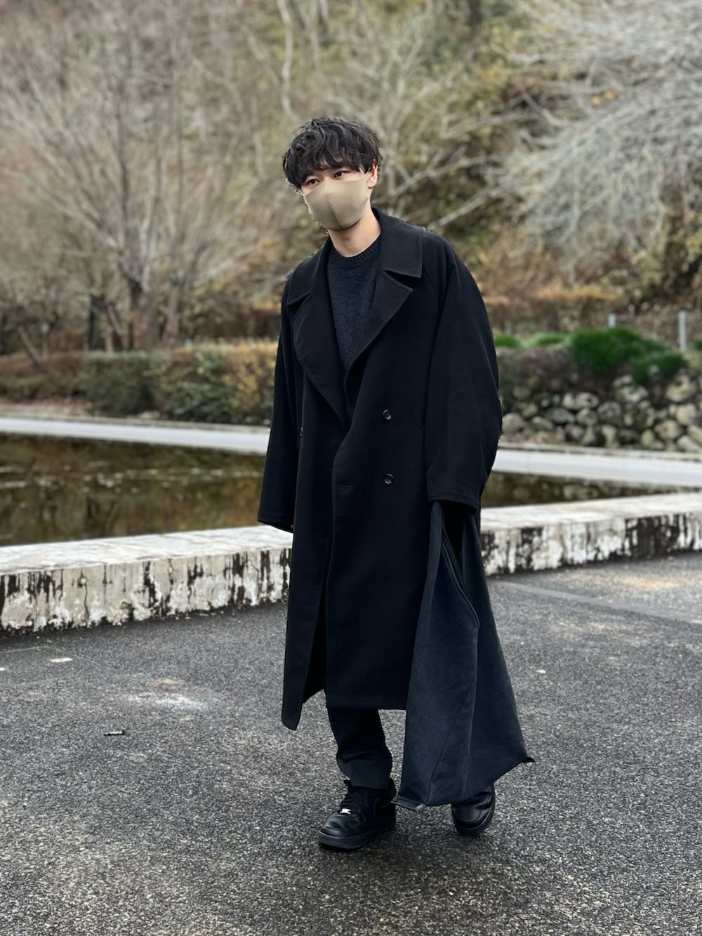 ブラック系のジャケット/アウター、ブラック系のニット/セーター、グレー系のスラックスを着用したメンズの冬コーディネートの2枚目の写真