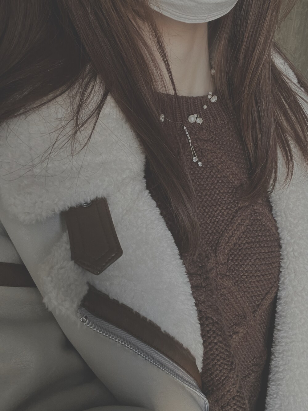 ホワイト系のムートンコート、ブラウン系のニット/セーターを着用したレディースの秋コーディネートの2枚目の写真