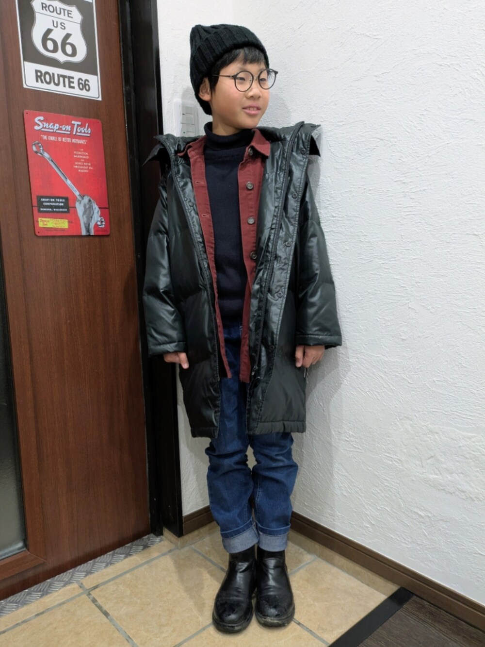 ブルー系のデニムパンツ、ブラック系のニット/セーター、レッド系のシャツ/ブラウスを着用したキッズの冬コーディネートの2枚目の写真