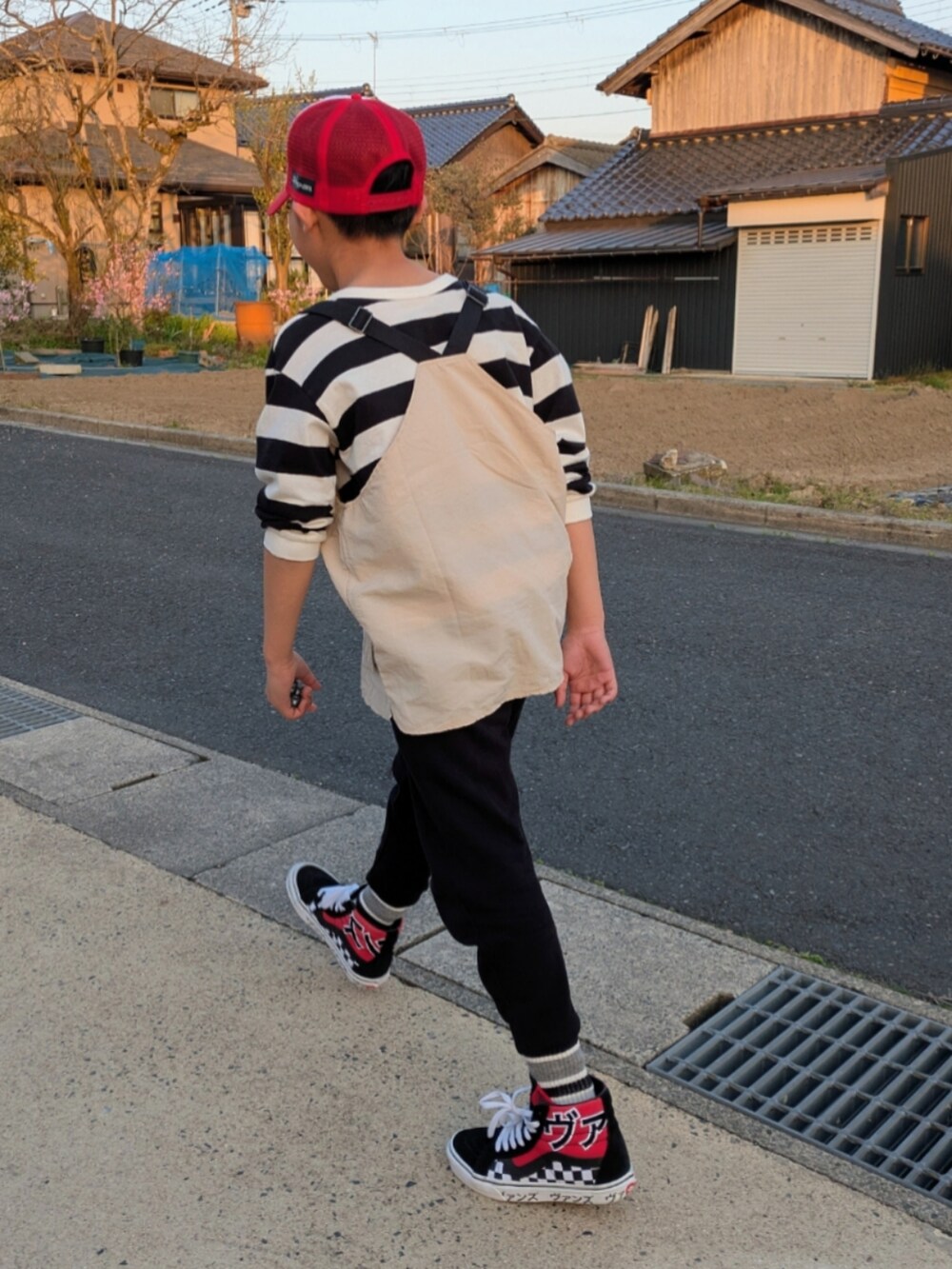 ブラック系のスウェットパンツ、その他のTシャツ/カットソー、ベージュ系のベストを着用したキッズの春コーディネートの4枚目の写真