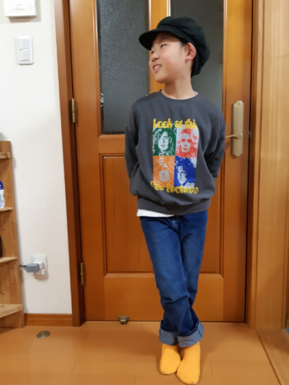 ブルー系のデニムパンツ、グレー系のスウェット、オレンジ系のダウンベストを着用したキッズの春コーディネートの2枚目の写真