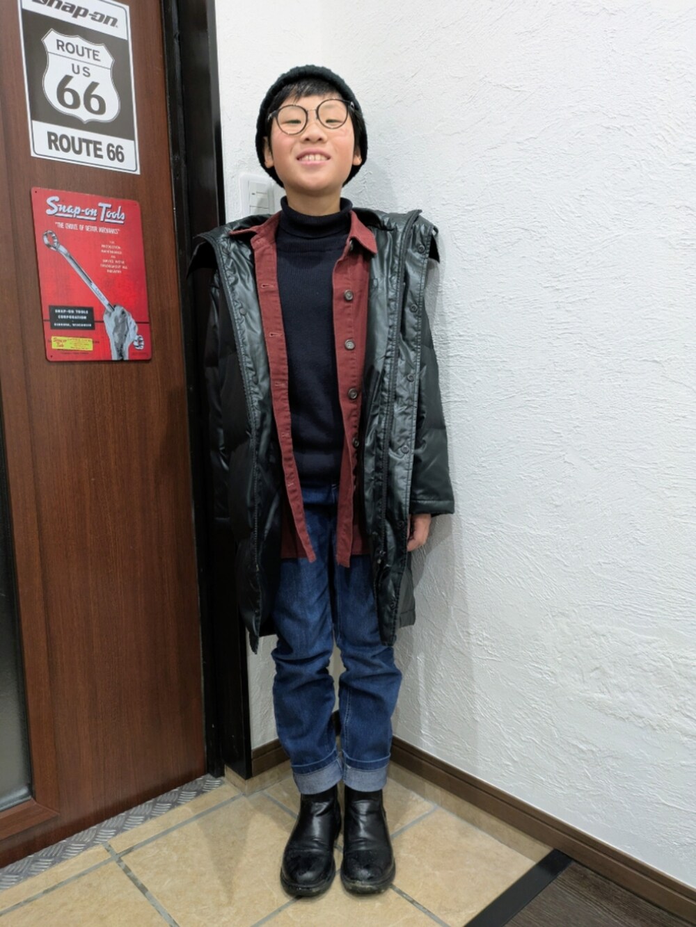 ブルー系のデニムパンツ、ブラック系のニット/セーター、レッド系のシャツ/ブラウスを着用したキッズの冬コーディネートの4枚目の写真