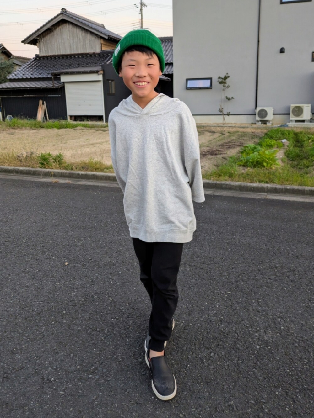 グレー系のパーカー、ブラック系のスリッポン、ブラック系のレギンス/スパッツを着用したキッズの秋コーディネートの4枚目の写真