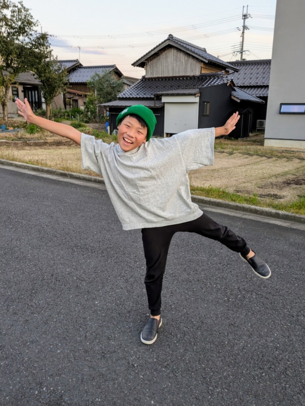 グレー系のパーカー、ブラック系のスリッポン、ブラック系のレギンス/スパッツを着用したキッズの秋コーディネートの5枚目の写真